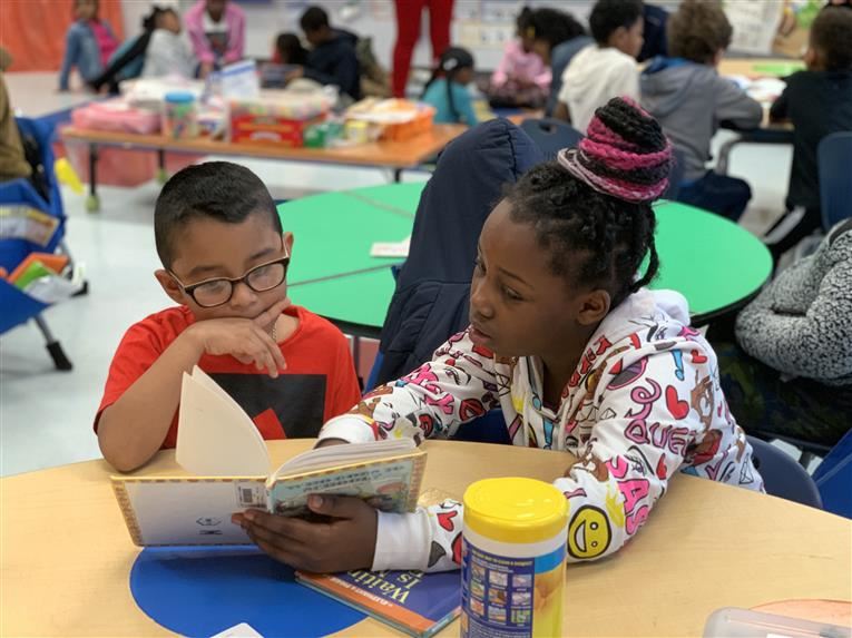 Kyra reading to Kindergarten