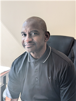 Photo of Mr. France, an African American man with a shaved head in a gray polo shirt