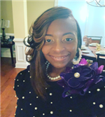 Photo of Ms. Faison-Johnson, a smiling African American woma wearing a beaded sweater.